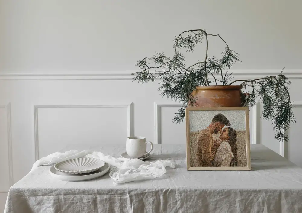 Gerahmtes Paar-Fotomosaik mit Stirnkuss auf einem gedeckten Tisch, eine romantische Geschenkidee